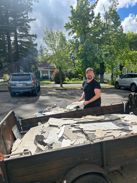 Casey loading debris trailer after a demolition job